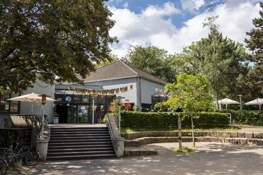 Cafe Friedolin BuezE Verzierte Terrasse mit Wimpelgirlande vor dem Bürgerzentrum Ehrenfeld mit umliegendem Park.