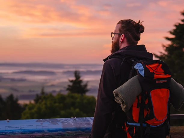 Sonnenaufgang Eisenberg Ein Mann genießt den Sonnenaufgang auf dem Eisenberg bei Korbach