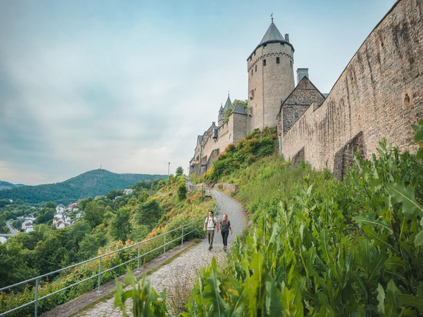 Wandernde an der Burg Altena Zwei Wandernde auf dem Sauerland-Höhenflug unterhalb der Burg Altena