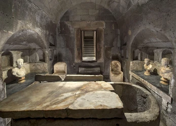 Römergrab Weiden Ein eindrucksvoller römischer Grabraum mit steinerner Decke, Skulpturen und steinernen Bänken.