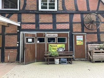 Hofladen Bröker, Freren Fachwerkgebäude mit geöffneten Holztüren, Schild Hofladen, Bank mit Pflanzen davor, rustikale Atmosphäre
