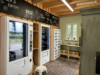 Hofladen Pott-Stopp Lingen Wachendorf ©Emsland Tourismus GmbH (6).JPEG Innenraum eines modernen Hofladens mit Verkaufsautomaten für regionale Produkte und Eierfächer.