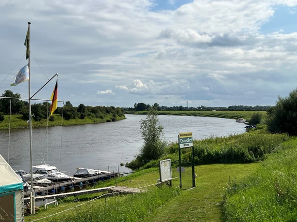 Boote und Fluss an einem ruhigen Sommertag mit weitem Himmel im Wassersportverein Langwedel.