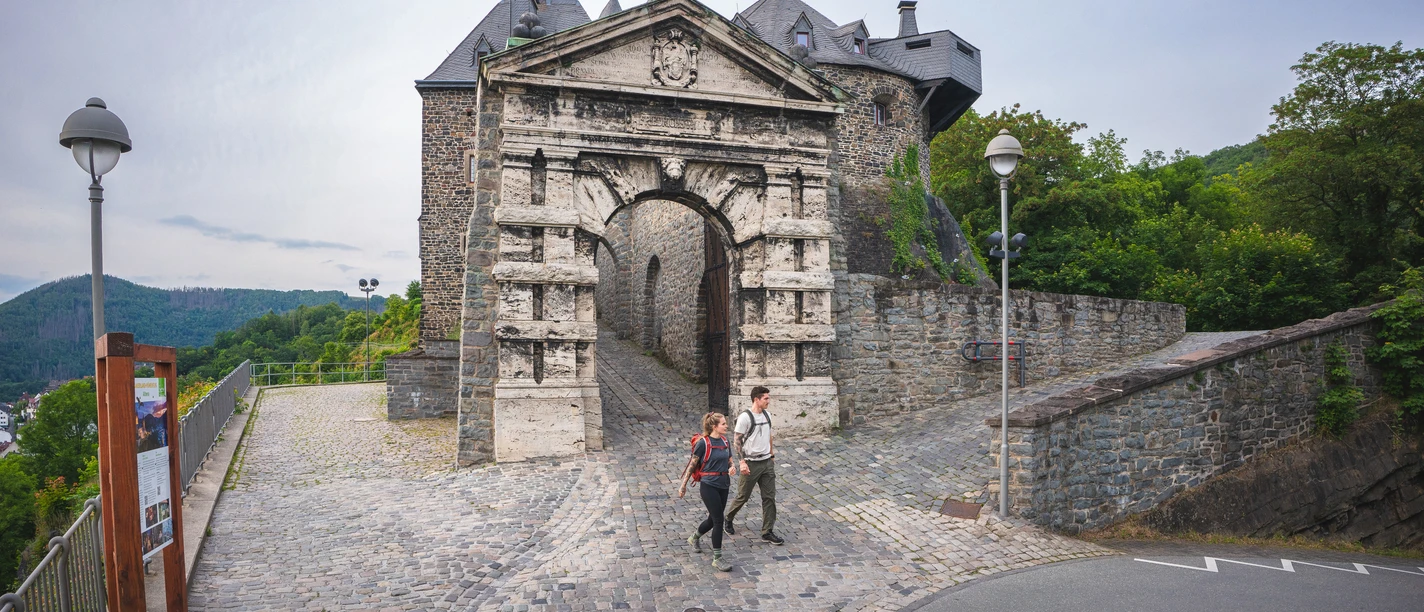 Zwei Wanderer am Burgtor der Burg Altena am Startpunkt vom Sauerland-Höhenflug Burg Altena der Startpunkt vom Sauerland-Höhenflug