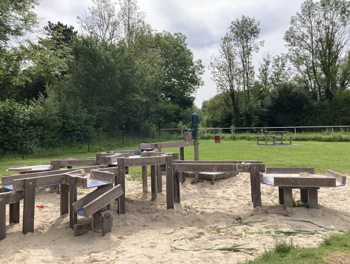 Borchen_Wasserspielplatz ©Kreis Paderborn.jpeg Wasserspielplatz mit Holzrinnen und Sand, umgeben von Bäumen und Wiesen im Kreis Paderborn.