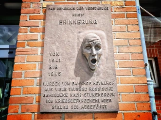Gedenktafel am Bahnhof Hövelhof Gedenktafel am Hövelhof Bahnhof mit Relief eines schreienden Gesichts erinnert an Kriegsgefangene.