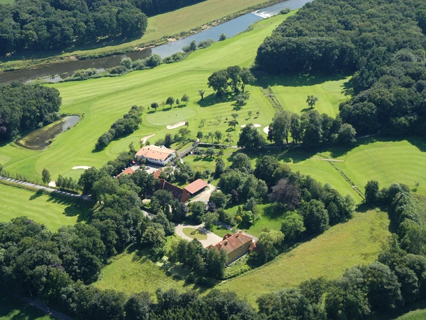 Luftaufnahme des weitläufigen Golfclubs Emstal mit gepflegten Fairways, Teich und umgebenden Wäldern.
