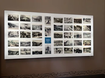 Eine beleuchtete Wand zeigt eine Sammlung historischer Schwarz-Weiß-Fotografien aus Bad Wünnenberg.