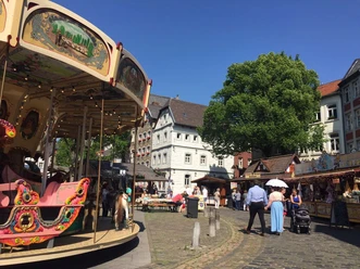 Platz mit Kopfsteinpflaster, auf dem sich ein Karussell dreht.