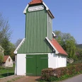 Das Feuerwehrgerätehaus Schnathorst besteht aus einem grün-weiß gestreiften Turm mit roten Dachziegeln.