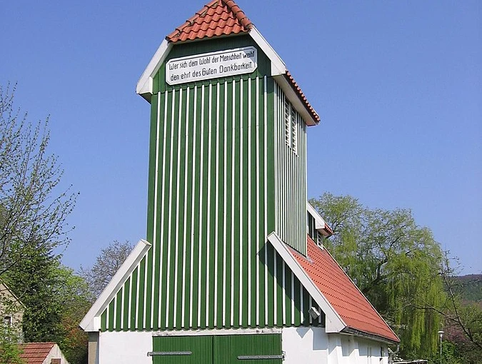 Das Feuerwehrgerätehaus Schnathorst besteht aus einem grün-weiß gestreiften Turm mit roten Dachziegeln.