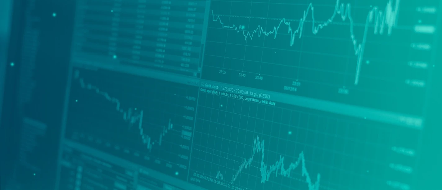 Investment Grafik Computermonitore mit Finanzdaten und Kursdiagrammen in blauen Farbtönen.