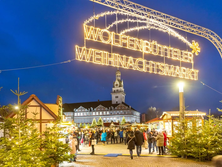 Weihnachtsmarkt Wolfenbüttel Leuchtender Schriftzug Wolfenbütteler Weihnachtsmarkt überspannt den Eingangsbereich zu einem stimmungsvollen MarktIlluminated Wolfenbüttel Christmas Market lettering spans the entrance area to an atmospheric marketOplyste Wolfenbüttel-julemarkedsbogstaver spænder over indgangsområdet til et stemningsfuldt markedVerlichte Wolfenbüttel Kerstmarkt belettering overspant de ingang van een sfeervolle markt