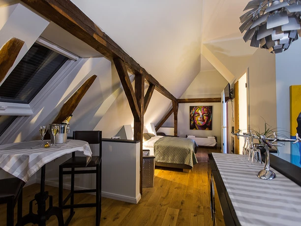 Soul Place John F. Kennedy Gemütliches Loft mit schrägem Holzbalken, stilvoller Kunst an den Wänden und einem Dachfenster.