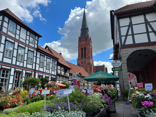 Wochenmarkt Nienburg Wochenmarkt in Nienburg: Fachwerkhäuser, bunte Blumenstände und die markante St.-Martins-Kirche.
