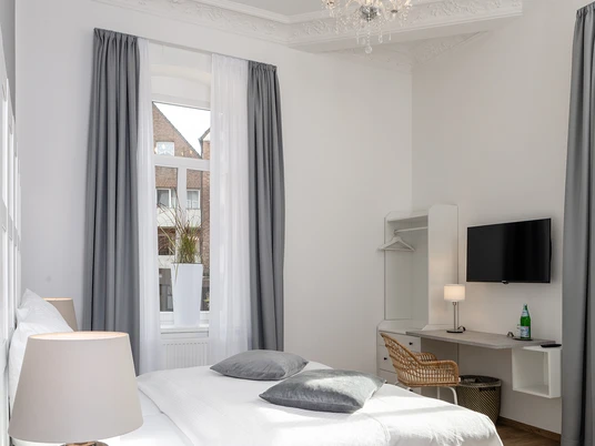 Hotel Markt 5 - Zimmer Helles, elegant eingerichtetes Zimmer mit Doppelbett, Kronleuchter und moderner Ausstattung.