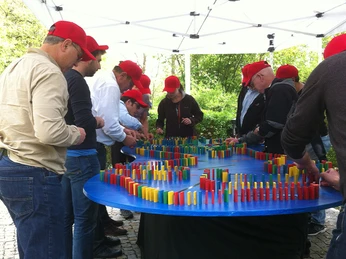 mSa Teamparcours Team mit roten Kappies baut ein Dominospiel aufThe team with the red caps is setting up a domino game.