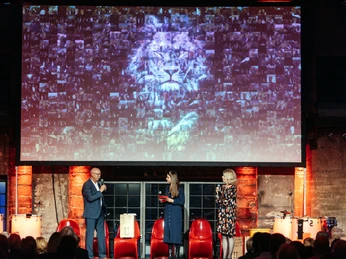 Großartige Präsentation – Business-Event mit beeindruckender Visualisierung 3 Personen stehen auf der Bühne vor einer großen Leinwand und halten eine Rede Three people are standing on the stage in front of a large screen and giving a speech.