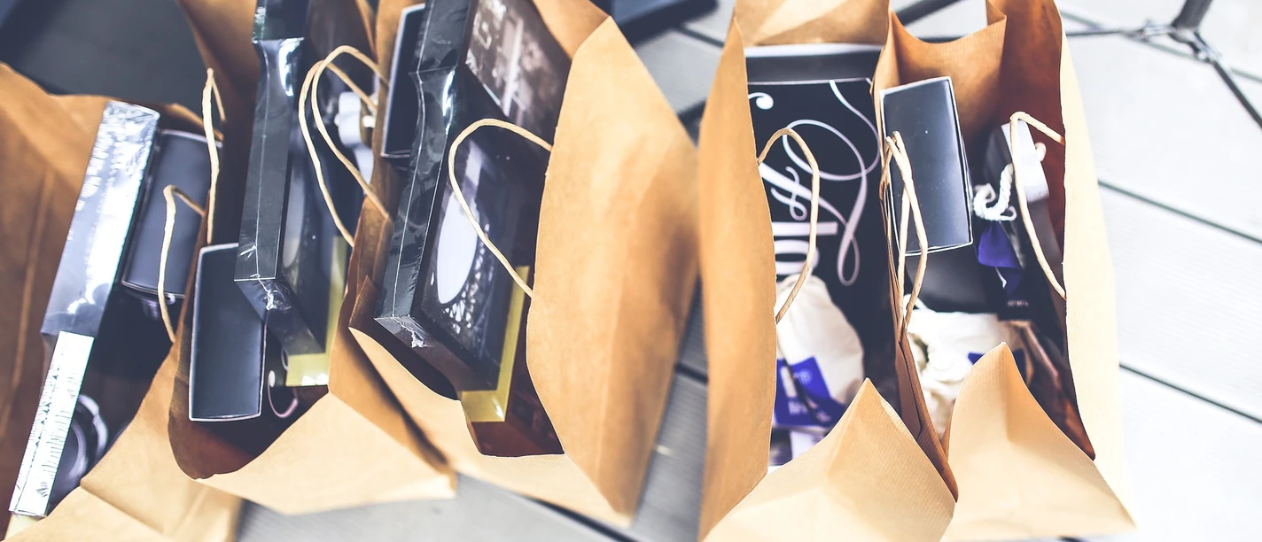 verkaufsoffener-sonntag Einkaufstüten aus Papier stehen voll bepackt auf dem Boden