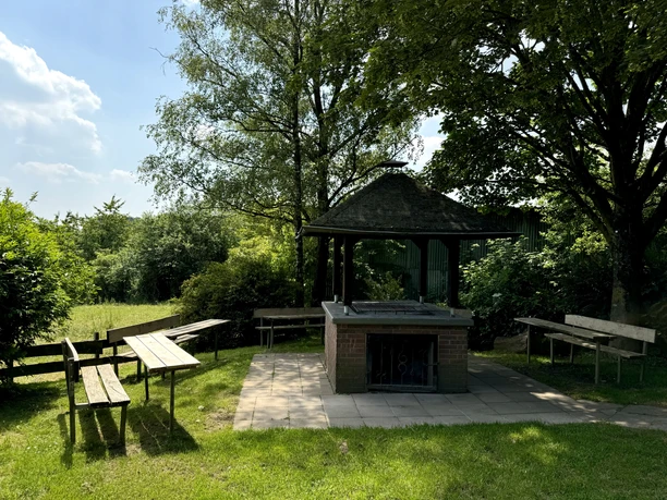 Grillhütte Hohkeppel Überdachter Grillplatz im Grünen mit Bänken und Tischen, umgeben von Bäumen und Wiesen im Freien.