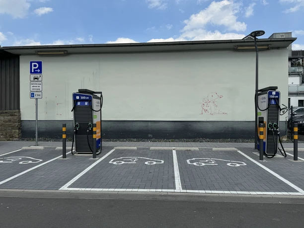 Ladesäule Engelskirchen Zwei Ladestationen für Elektrofahrzeuge mit gekennzeichneten Parkplätzen und einem Ladetarif-Schild.