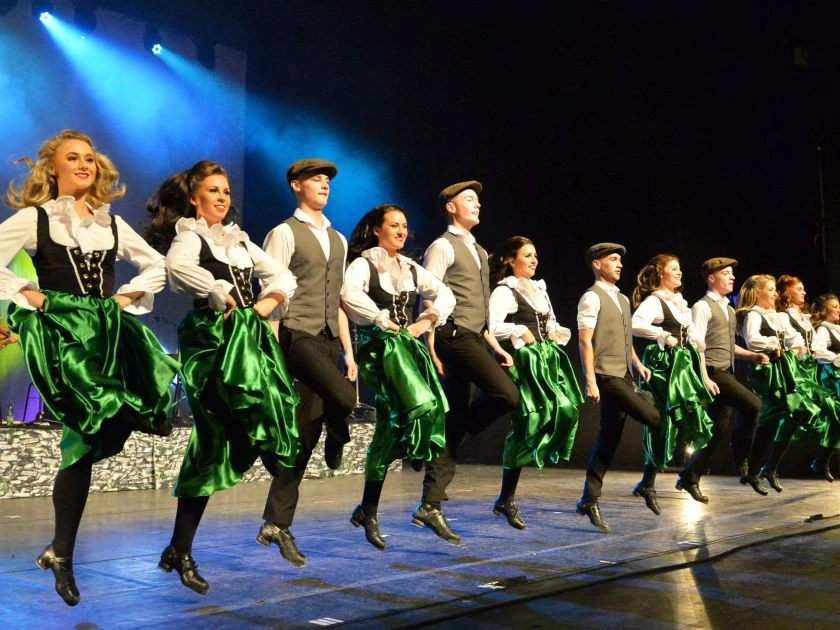 Danceperados Tänzer in traditioneller irischer Kleidung führen eine synchrone Stepptanz-Performance auf der Bühne auf.
