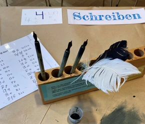 Writing station with quills and ink in museum Fragen Erklären