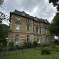 Kunstmuseum Villa Zanders Historisches, dreistöckiges Gebäude mit schiefergedecktem Dach, umgeben von begrüntem Garten.
