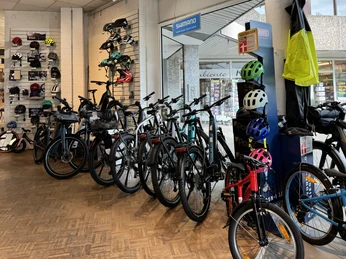 Cycle-M Fahrradgeschäft mit ausgestellten Fahrrädern und Helmen, modern gestaltete Verkaufsfläche.