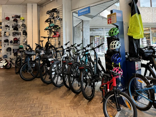 Cycle-M Fahrradgeschäft mit ausgestellten Fahrrädern und Helmen, modern gestaltete Verkaufsfläche.