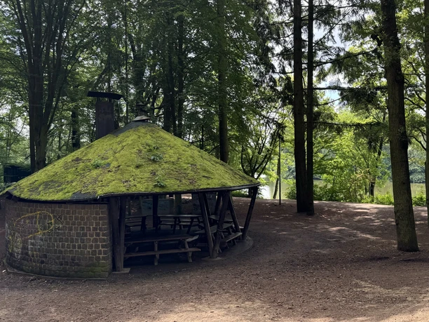 Grillhütte Saaler Mühle Runde, moosbewachsene Schutzhütte aus Holz und Stein in einem lichtdurchfluteten Wald.