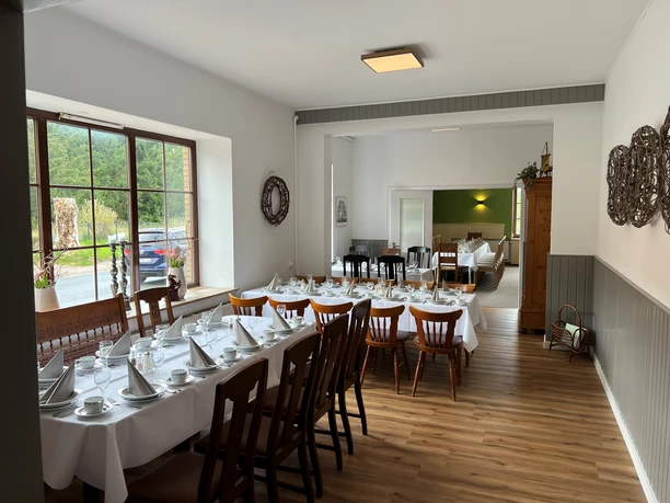 Wätjens Klönschnack Ein einladender Raum mit gedeckten Tischen und eleganten Stühlen, perfekt für gesellige Treffen.