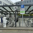 Kreishaus Heidkamp (Ladesäule) Barrierefreie Ladestation für Elektrofahrzeuge und Fahrräder mit überdachtem Bereich in städtischer Umgebung.