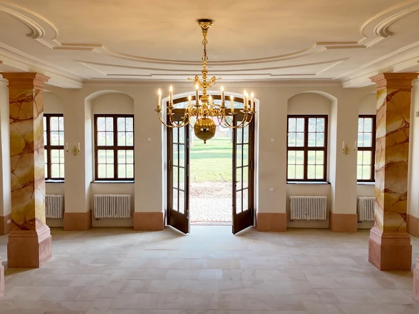 Jagdhaus Kössern - Tür zum Barockgarten Das Bild zeigt den hinteren Saal im Erdgeschoss des Jagdhauses mit der Tür zum Garten.