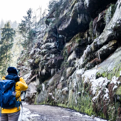 Winterliches Polenztal Wanderer im Winter durch das verschneite Polenztal, umgeben von vereisten Felsen und Tannen.