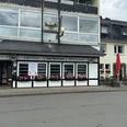 Hotel-Restaurant Zum Holländer - Außenansicht Hotel und Restaurant mit schwarzen Fensterläden und bunten Blumenkästen, angrenzendem Außenbereich.
