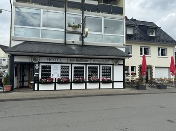 Hotel-Restaurant Zum Holländer - Außenansicht Hotel und Restaurant mit schwarzen Fensterläden und bunten Blumenkästen, angrenzendem Außenbereich.