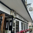 Hotel-Restaurant Zum Holländer - Außenansicht Hotelgebäude im Fachwerkstil mit Blumen und traditionellen Schildern. Hintergrund zeigt eine Straße.