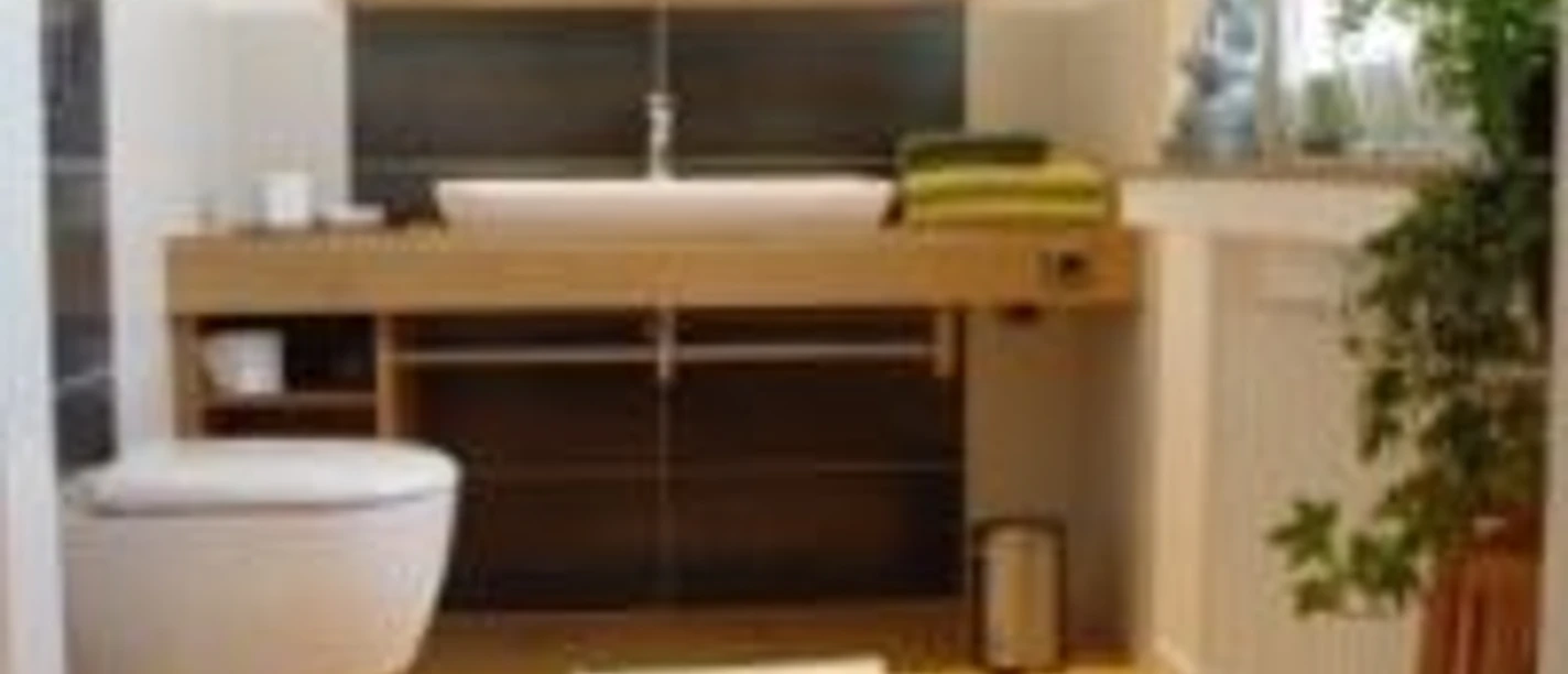 Modernes Badezimmer mit Holzfußboden, Wandwaschbecken, wandhängender Toilette und grünen Handtüchern.