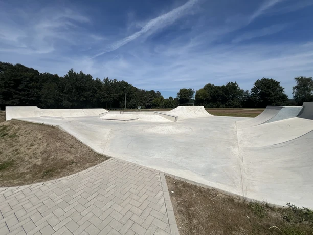 Skaterpark Much Moderner Skatepark in Much mit glatten, weißen Betonelementen und breitem Himmel im Hintergrund.