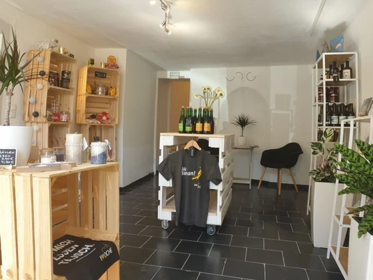 Innenraum des Ladens mit verschiedenen Regalen und Produkten wie Flaschen und Textilien.