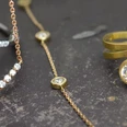 Goldschmiede Albath_Diamantschmuck.jpg Verschiedene Schmuckstücke aus Gold mit funkelnden Diamanten auf dunklem Untergrund.