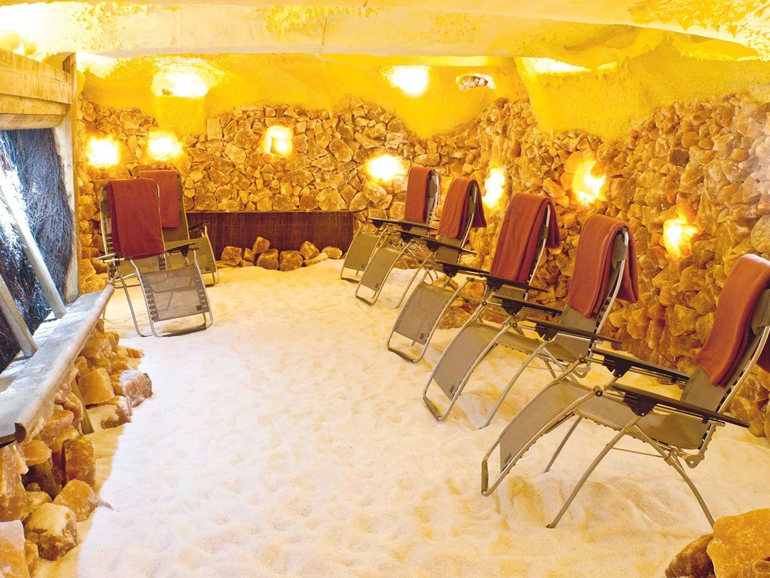 Das Bild zeigt den Ruhebereich in der Salzgrotte. Zu sehen sind Liegestühle.