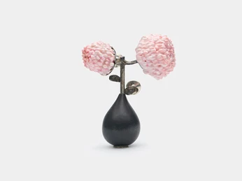 Saerom Kong, brooch "Cherry Blossom II" Eine handgefertigte Brosche aus Metall zeigt zartrosa Kirschblüten auf dunkelgrauem Grund.A handmade metal brooch features delicate pink cherry blossoms on a dark gray background.