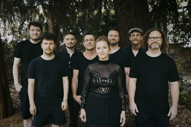Leyla Trebbien & Band Musikgruppe steht im Wald zwischen hohen Bäumen
