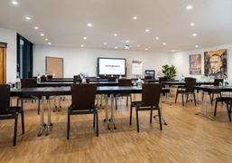 Babilon Saal Konferenzraum mit Parlamentarischer Bestuhlung, Gemälden an den Wänden und TVConference room with parliamentary seating, paintings on the walls and a TV