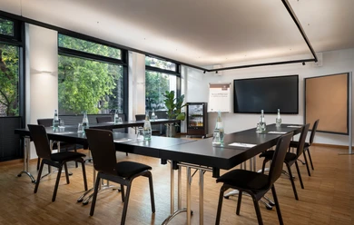 Raum Hürth Small conference room with u-shaped seating, daylight and TV