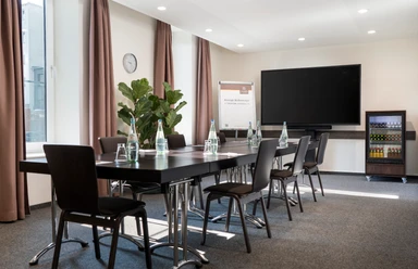 Raum Schlick Small conference room with block seating, daylight and TV