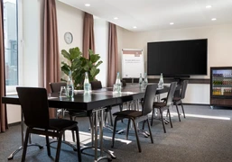 Raum Schlick Kleiner Konferenzraum mit Blockbestuhlung, Tageslicht und TVSmall conference room with block seating, daylight and TV