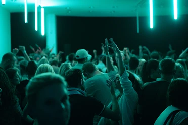 Dichte Menschenmenge tanzt im neonbeleuchteten Club.
